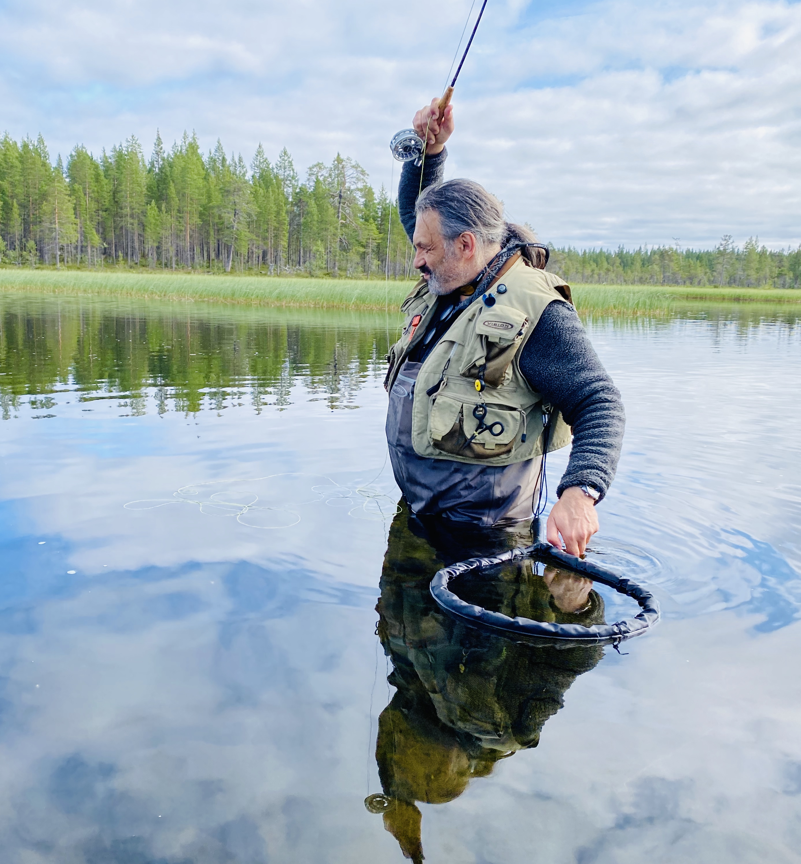 Boris with his rod held high and net ready to land a brown trout
