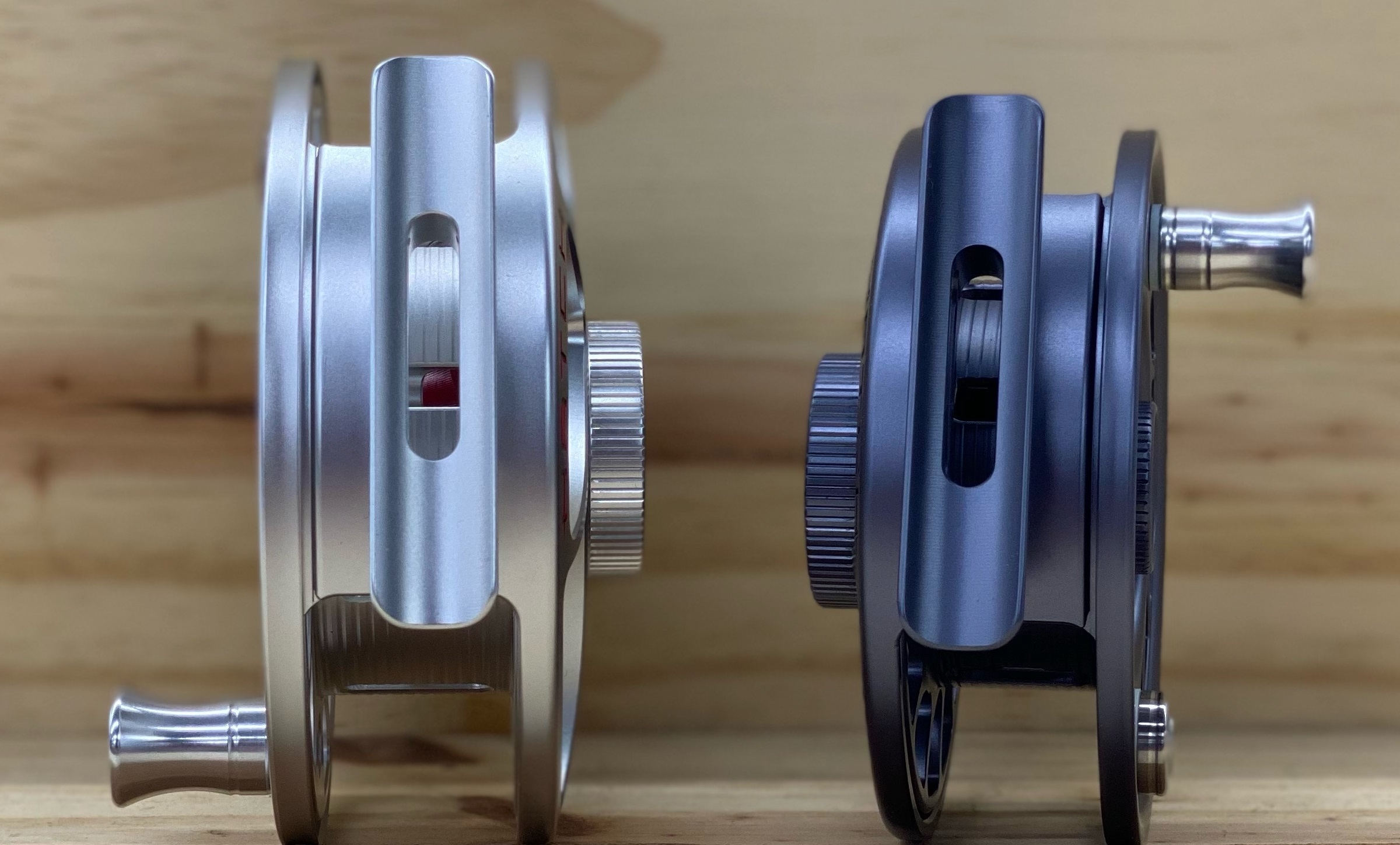 Two Hatch Iconic reels in different colors displaying the reel seat, handle and drag knob