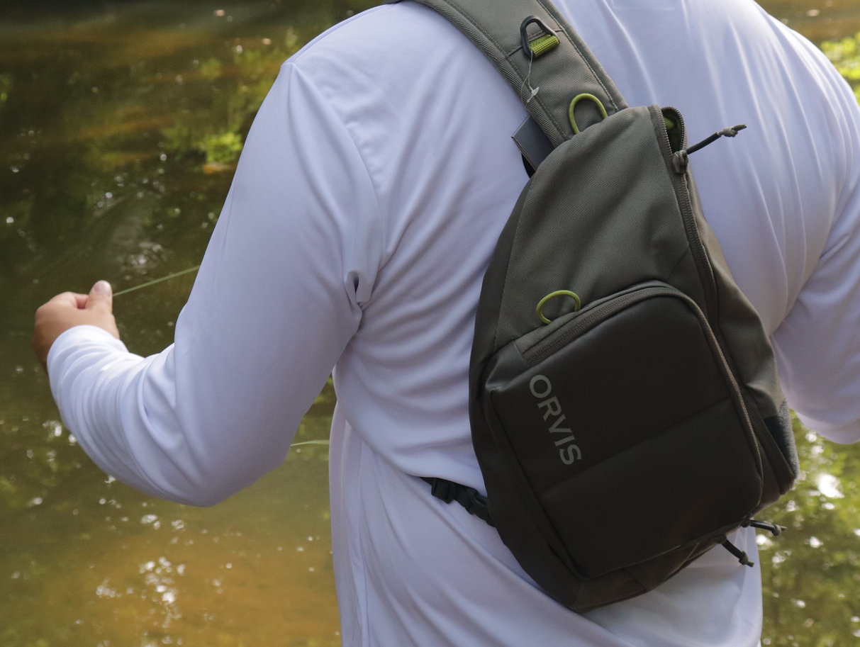 An angler fishing with an Orvis Mini Sling settled on his back